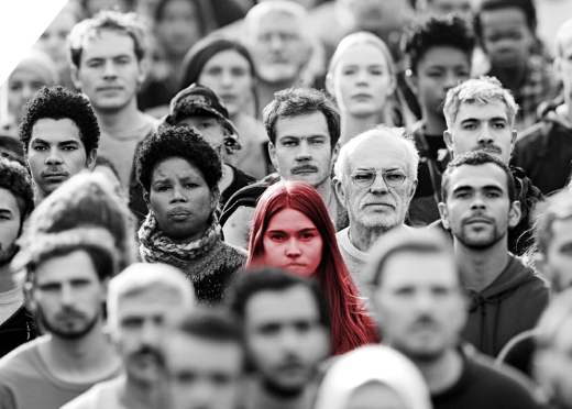 A crowd of faces walking  down a city street, with one  young woman’s face  highlighted in a soft red.